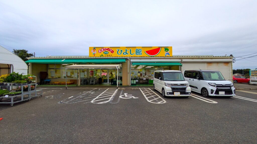 ひよし館の外観。ファンシーな看板と駐車場に停まった車が並ぶ。
