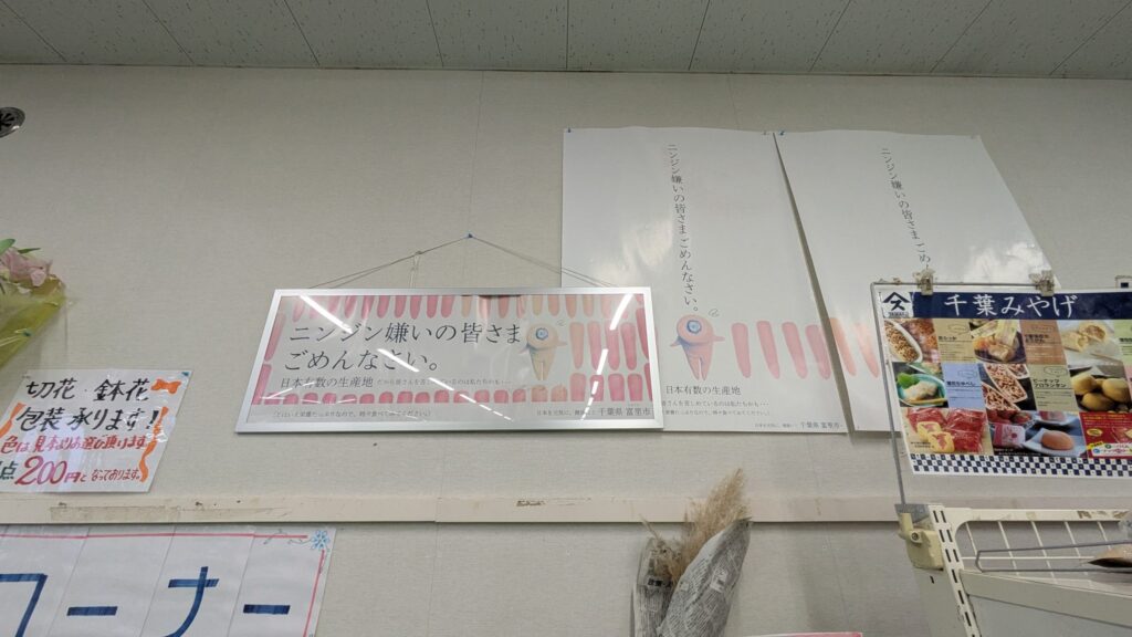 店内の壁に掲示された掲示物で、ニンジンに関するメッセージと謝罪文が書かれている。