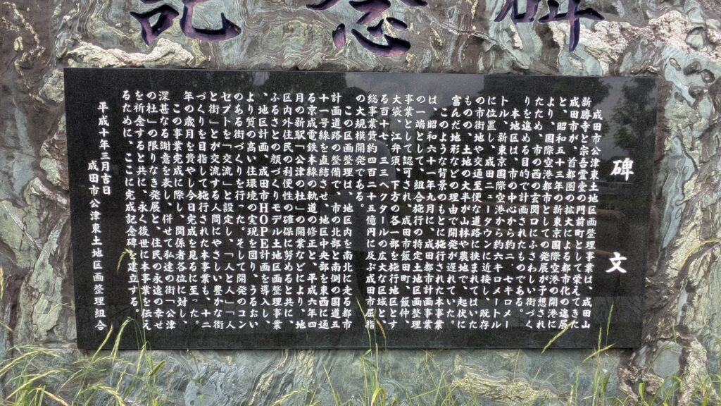 黒い石板に刻まれた記念碑の文字が写っている。文字は日本語で、歴史や地域についての解説を含む内容である。