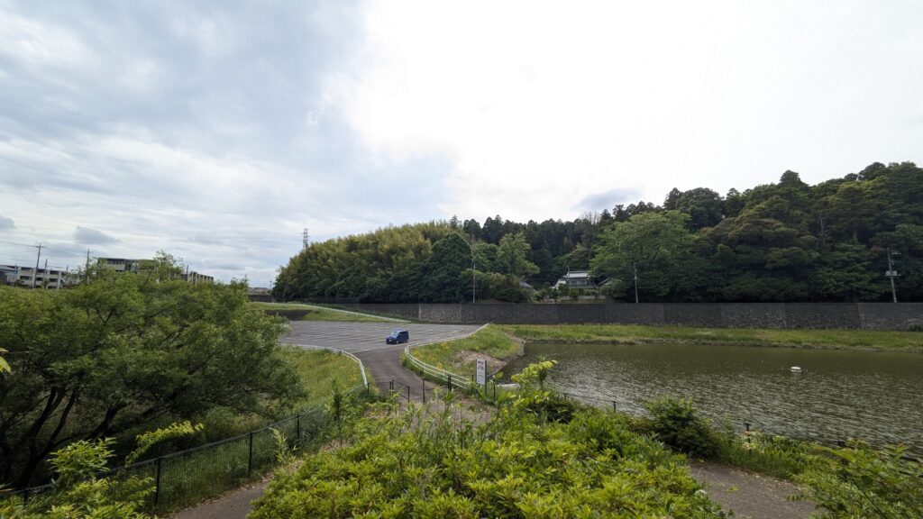 田舎の風景に沿った道路と緑豊かな山々が見える静かな湖の近くの風景です。