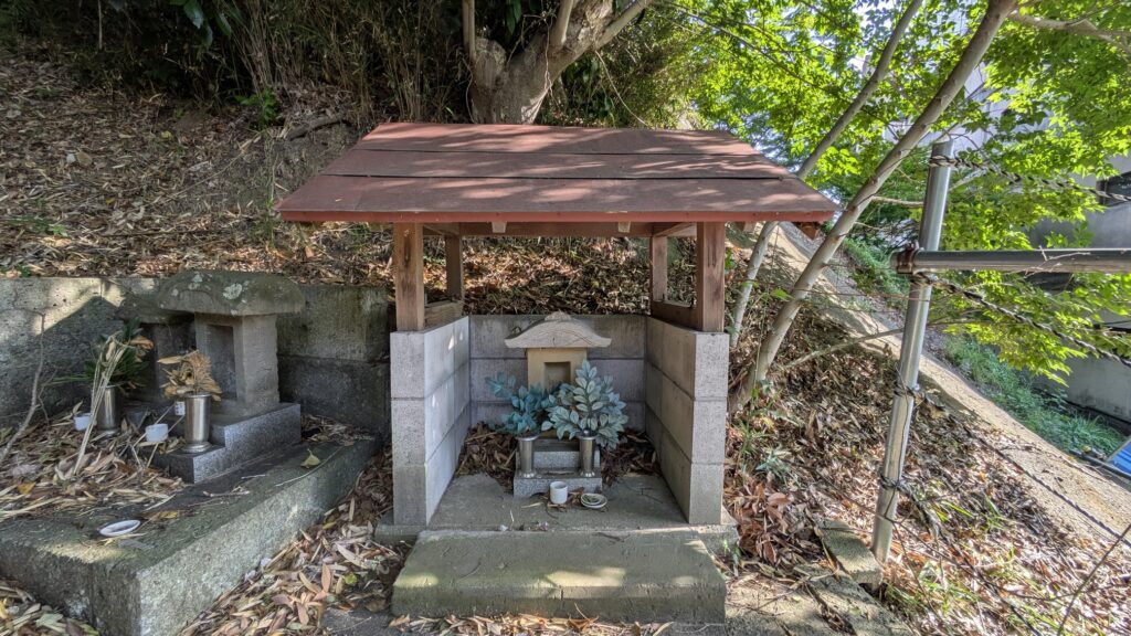 山の中にある小さな神社のような建物とその周辺の風景。