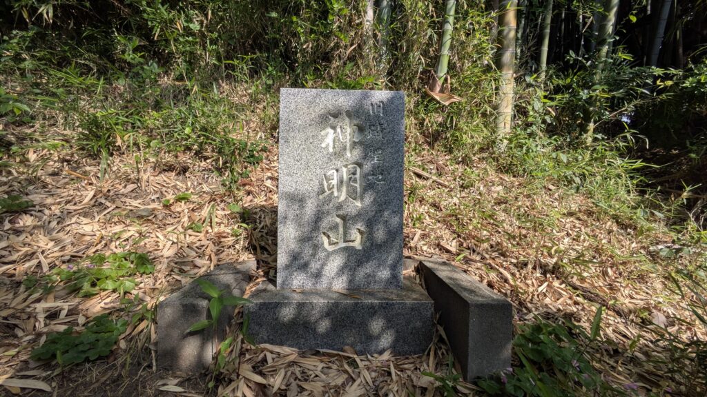 神明山の石碑が竹林の中に立っている風景