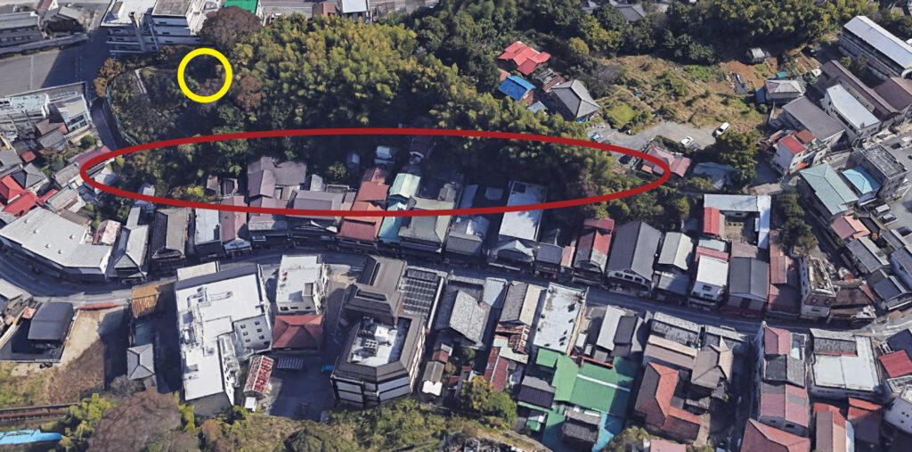 住宅地と緑地帯を俯瞰した aerial view の画像。赤い円で囲まれた区域と、黄色い円で示された特定の位置が含まれている。