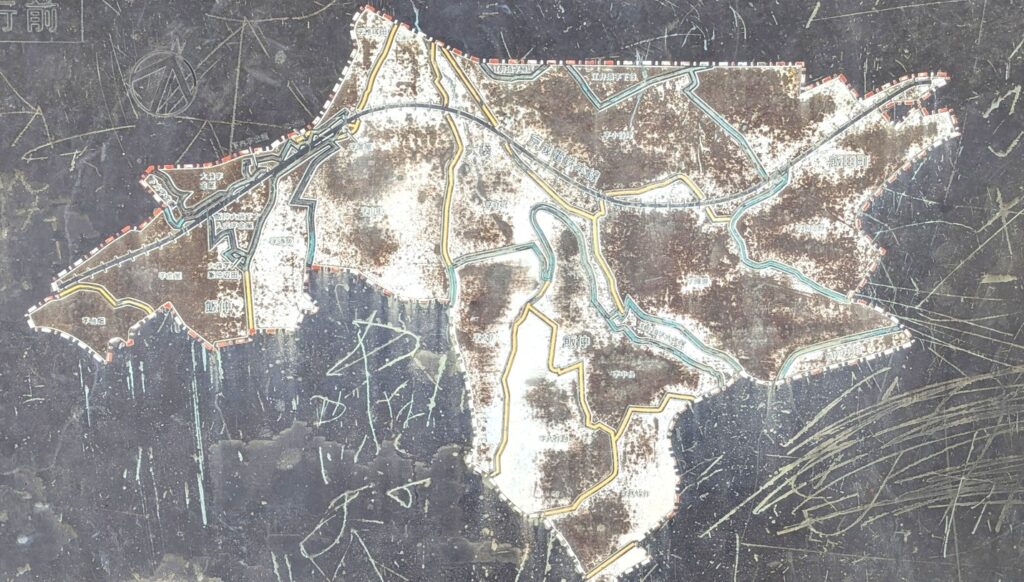 古い地図の画像。地形や道路が描かれており、色あせた部分が目立つ。