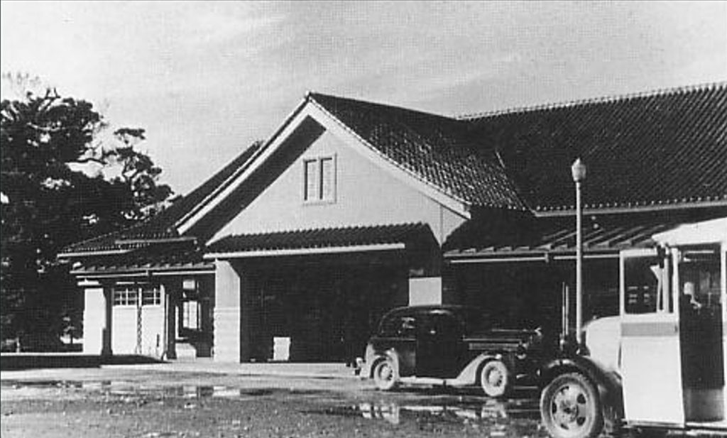 1920年代の建物と古い自動車が写っているモノクロ写真