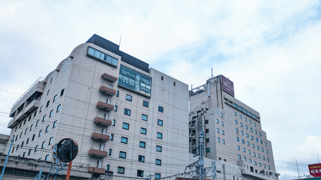 2026年10月撮影・成田市花崎町のホテルウェルコ成田 線路側から見た本館と別館|営業中