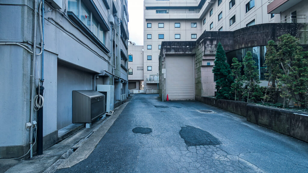 2026年10月撮影・成田市花崎町 ホテルウェルコ成田の裏手の路地とシャッター|営業中