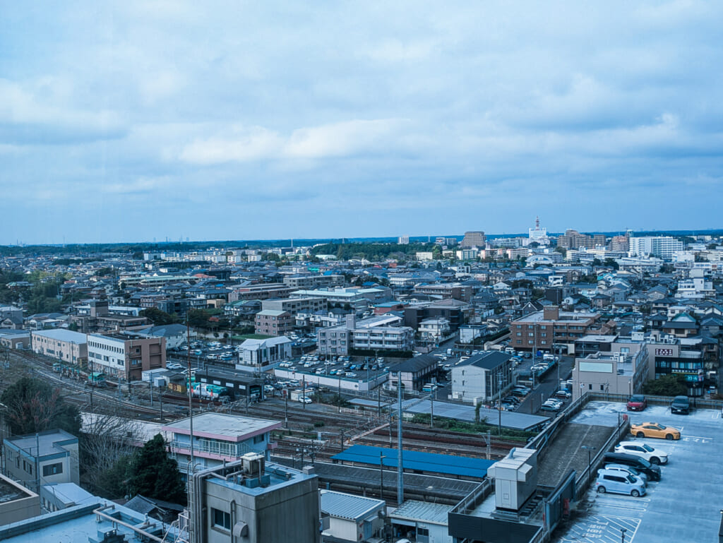 2026年10月撮影・成田市花崎町のホテルウェルコ成田 最上階から見た線路と成田の街並み|営業中