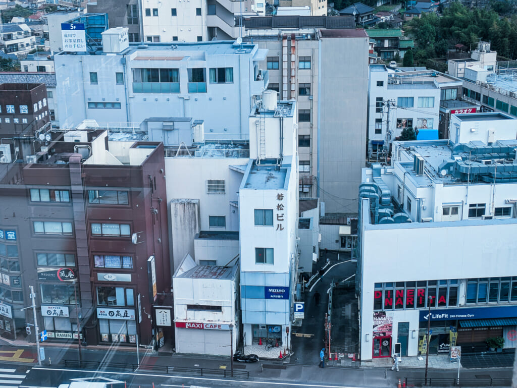 2026年10月撮影・成田市花崎町のホテルウェルコ成田 最上階から見下ろした駅前通りのビル|営業中