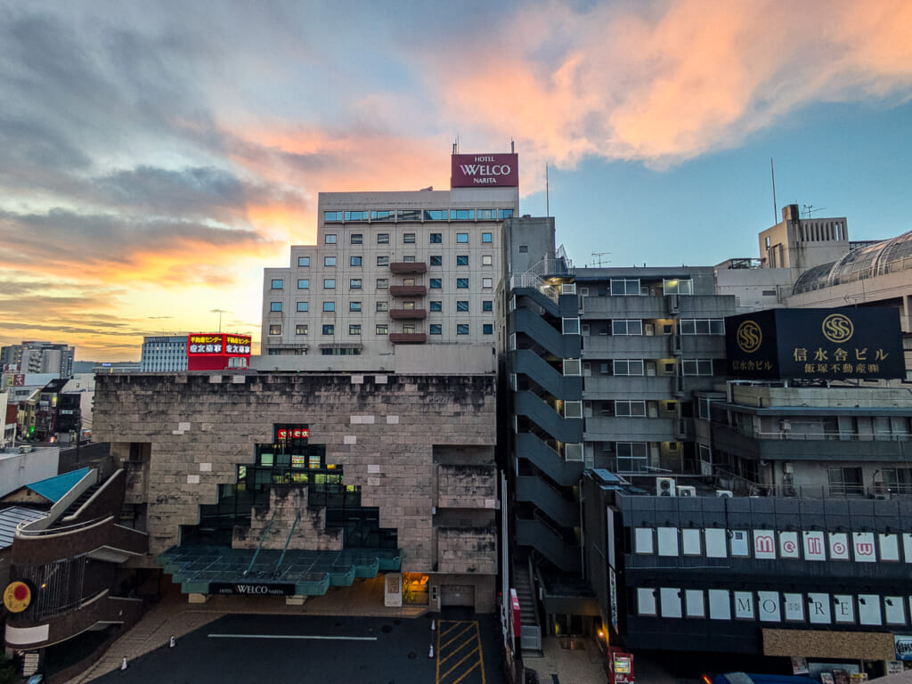 2026年10月撮影・成田市花崎町のホテルウェルコ成田 早朝の空と本館の正面|営業中