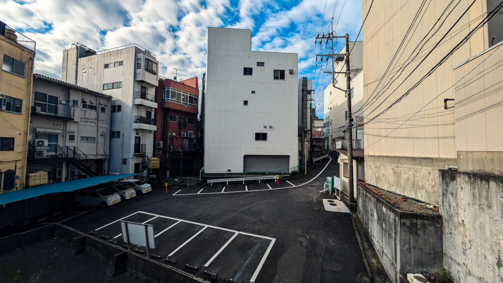 2026年撮影・成田市花崎町の千葉交通京成成田駅前ビル 裏手から見た外観と駐車場｜現存