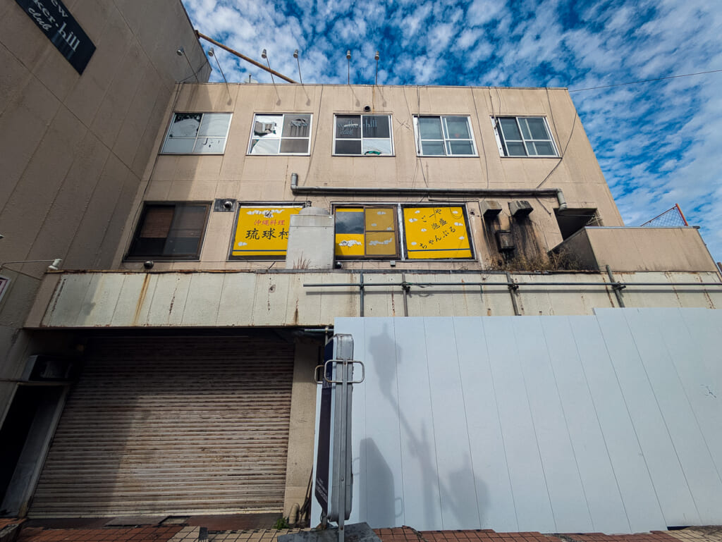 2026年10月撮影・成田市花崎町の開運ビル 琉球村の窓の看板とシャッター|閉店・建物あり