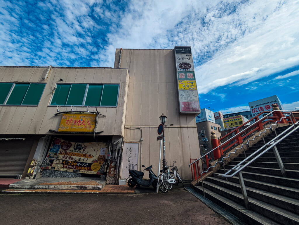 2026年10月撮影・成田市花崎町の開運ビル 開運橋のたもとの店先と階段|現存
